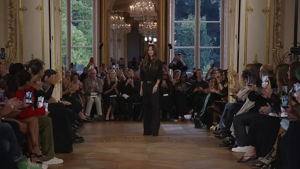 Victoria Beckham dons chic black ensemble and beams with pride while receiving rapturous applause from husband David, daughter Harper and sons Brooklyn and Cruz at her Paris Fashion Week show