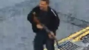 Moment hooded man stalks past houses with ‘machine gun’ as cops hunt suspect